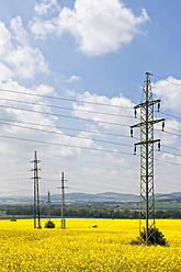 Germany, Bavaria, View of electricity pylon in rapeseed field - FOF003861