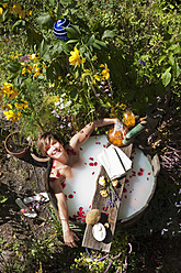 Austria, Salzburg, Flachau, Young woman taking milkbath in tun - HHF003881