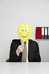 Germany, Businessman with smiley face balloon - ANBF000072