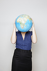 Deutschland, Geschäftsfrau versteckt ihr Gesicht mit Globus - ANBF000077