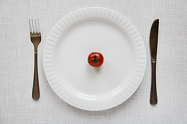 Deutschland, Tomate auf Teller mit Gabel und Messer - ANBF000018