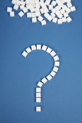 Sugar cubes question mark on blue background stock photo