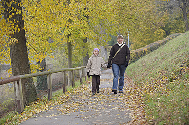 Deutschland, Bayern, Mutter und Tochter gehen im Herbst auf einem Fußweg - RUEF000836