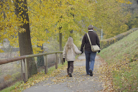 Deutschland, Bayern, Mutter und Tochter gehen im Herbst auf einem Fußweg, lizenzfreies Stockfoto