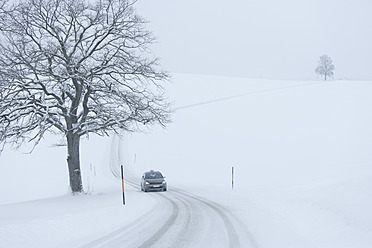 Germany, Upper Bavaria, View of car on snowy road - TCF002191