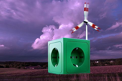 Grüne Steckdose in der Landschaft vor einer Windmühle - CSF015766