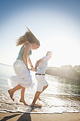 Spain, Mallorca, Couple running along beach - MFPF000017