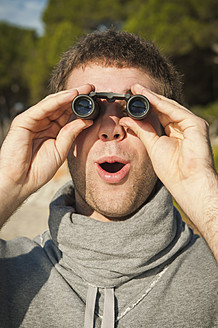 Spain, Mallorca, Young man looking through binocular - MFPF000020