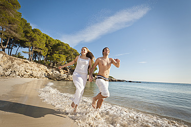 Spanien, Mallorca, Pärchen läuft am Strand entlang - MFPF000024