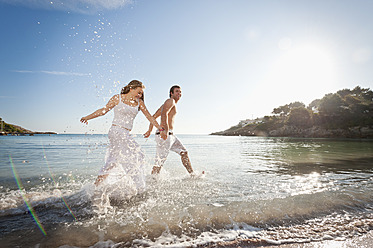 Spain, Mallorca, Couple running along beach - MFPF000025
