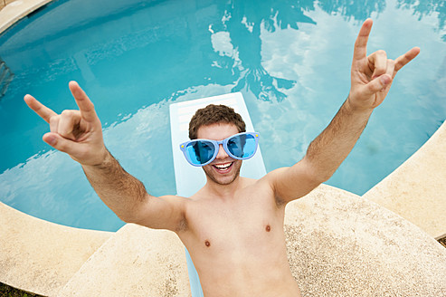 Spanien, Mallorca, Junger Mann mit lustiger Brille auf Sprungbrett, lächelnd - MFPF000036