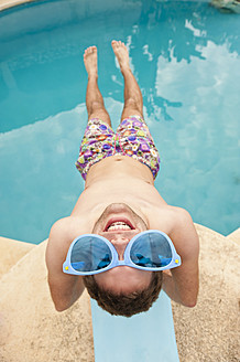 Spain, Mallorca, Young man with funny glasses on diving board, smiling - MFPF000037