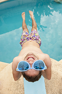 Spanien, Mallorca, Junger Mann mit lustiger Brille auf Sprungbrett, lächelnd - MFPF000037