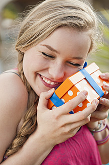 Spanien, Mallorca, Teenager-Mädchen hält Geschenkbox, lächelnd - MFPF000041