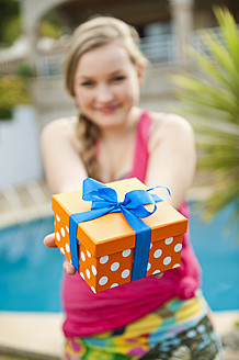 Spanien, Mallorca, Teenager-Mädchen hält Geschenkbox, lächelnd, Porträt - MFPF000043