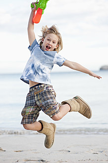 Spain, Mallorca, Boy with water gun on beach, portrait - MFPF000087