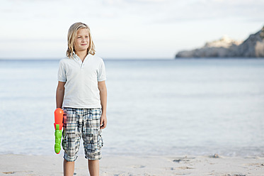 Spain, Mallorca, Boy with water gun on beach - MFPF000089
