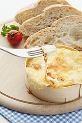 Baked oven cheese with bread on wood plate - MAEF004395