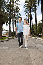 Spain, Mallorca, Palma, Couple walking along allee, smiling - SKF000947