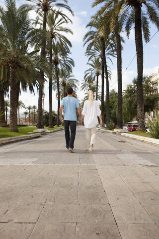 Spanien, Mallorca, Palma, Pärchen beim Spaziergang entlang der Allee, lizenzfreies Stockfoto