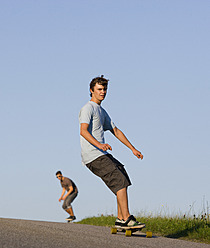 Österreich, Junge Männer beim Longboarden auf der Straße - WWF002088