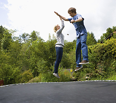 Österreich, Junger Mann und Frau springen auf Trampolin - WWF002138