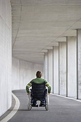 Austria, Mondsee, Young man sitting on wheelchair at subway - WWF002096