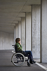 Austria, Mondsee, Young man sitting on wheelchair at subway - WWF002098