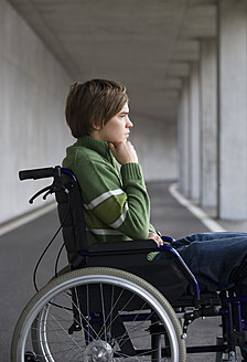 Austria, Mondsee, Young man sitting on wheelchair at subway - WWF002099