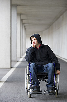 Austria, Mondsee, Young man sitting on wheelchair at subway - WWF002100