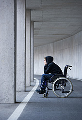 Austria, Mondsee, Young man sitting on wheelchair at subway - WWF002102