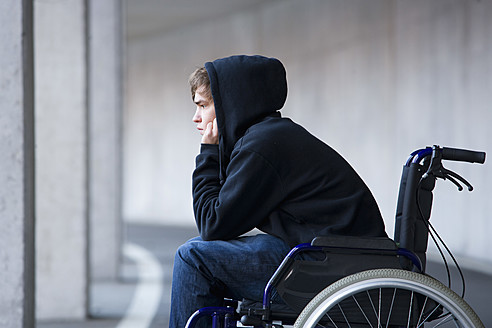 Austria, Mondsee, Young man sitting on wheelchair at subway - WWF002103