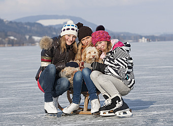 Österreich, Teenager-Mädchen auf Schlitten sitzend mit Hund, Porträt - WWF002286