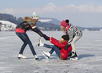 Austria, Teenage girl fallen on ice rink and friends helping her - WWF002344