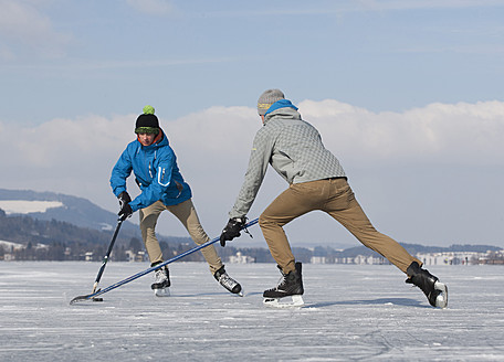 Austria, Teenage boys playing ice hockey on ice rink - WWF002345