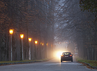 Austria, Car passing through road in foggy morning - WWF002150
