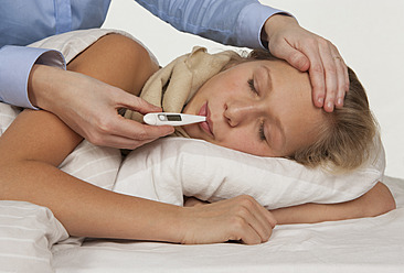 Female doctor checking teenage girl temperature with digital thermometer - WWF002197