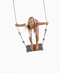 Austria, Teenage girl swinging in garden, portrait - WWF002247