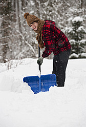 Österreich, Junger Mann beim Schneeschaufeln, Porträt - WWF002122