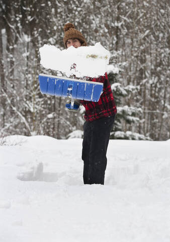 Österreich, Junger Mann beim Schneeschaufeln, Porträt, lizenzfreies Stockfoto