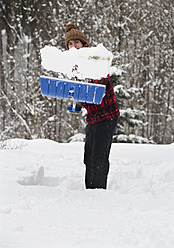 Österreich, Junger Mann beim Schneeschaufeln, Porträt - WWF002123