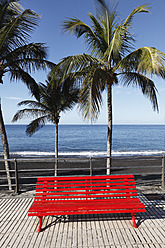 Spanien, Kanarische Inseln, La Palma, Blick auf rote Bank mit Palmen am Strand - SIEF002336