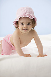 Baby girl crawling on blanket, smiling - SMOF000473