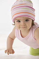Baby girl crawling on baby blanket, smiling - SMOF000476