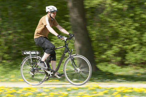 Deutschland, Bayern, München, Älterer Mann fährt Elektrofahrrad, lizenzfreies Stockfoto