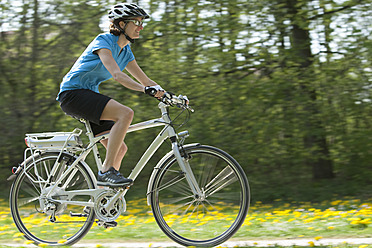 Germany, Bavaria, Munich, Mid adult woman riding electric bicycle - DSF000236