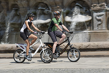 Germany, Bavaria, Munich, Man and woman riding electric bicycle - DSF000239