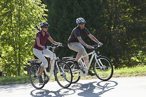 Deutschland, Bayern, Mann und Frau fahren Elektrofahrrad - DSF000244