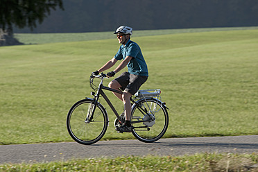 Deutschland, Bayern, Älterer Mann fährt Elektrofahrrad - DSF000250