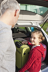 Germany, Leipzig, Father and daughter loading luggage into car - WESTF018425